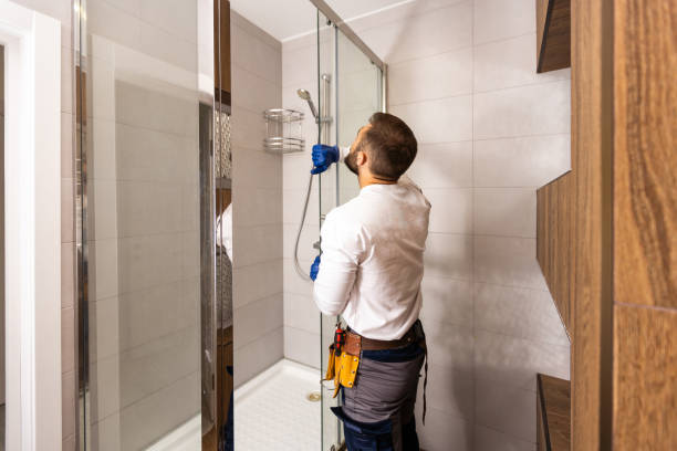 Plumber installing a shower cabin in bathroom. Shower and Bathtub Installation<br />